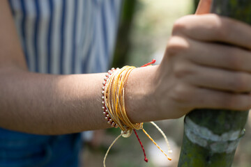 woman's hand with bracelets holding a bamboo stick