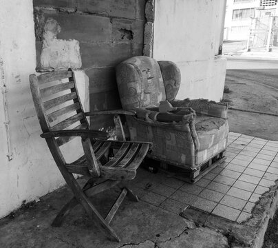 Black and white Photograph of old abandoned chair and sofa on the street