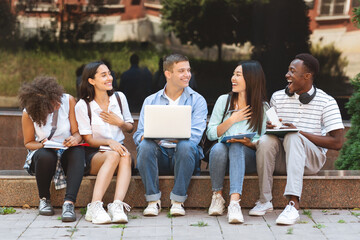 Break Between Classes. Happy students sitting on bench at university campus