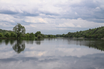 Beautiful river in the highlands in summer. Lake in an ecologically clean park reserve on a background of hills. A pretty landscape in the spring. Stock photo for design