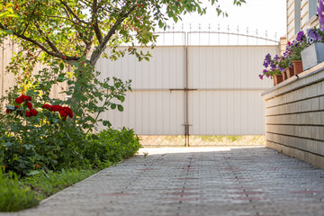 Front yard on residential home with tile path, flowers and cherry tree.