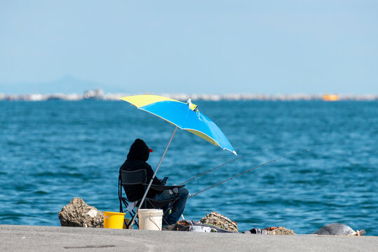  A Man Fishing In The Gulf Of La Spezia Under Umbrella