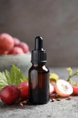 Bottle of natural grape seed oil on grey table. Organic cosmetic