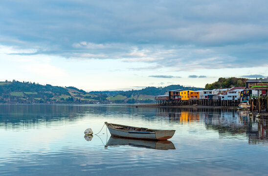 A lone fishing boat by the palafitos stilt houses in Castro, Chiloe Island, Chile.