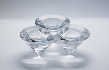A transparent glass candlestick with a support base and the top of which has three nozzles where the candles are placed to light.