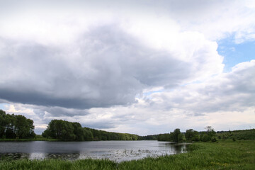 Landscape with a beautiful river and swans on a background of hills. Lake in the ecological zone in europe. Stock image for design.