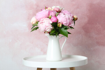 Bouquet of beautiful peonies in vase on white table