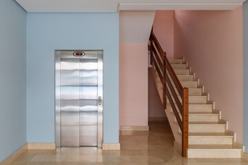 view of the elevator and stairwell in the entrance of a residential building © sergiy1975