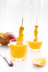 Fresh sliced mango and mango juice. Mango juice in two glasses.