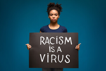 Black woman holding demonstration placard Racism is a Virus