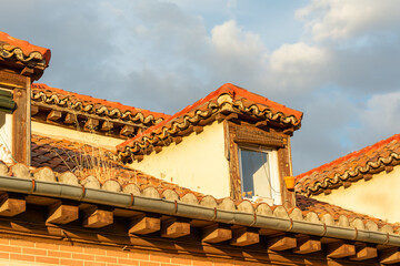 Fototapeta na wymiar View of rooftop and sky with clouds at sunset. Roof tiles