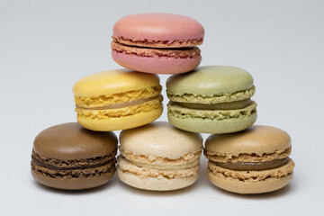 A stack of pastel-coloured macarons indoors against a soft neutral background.