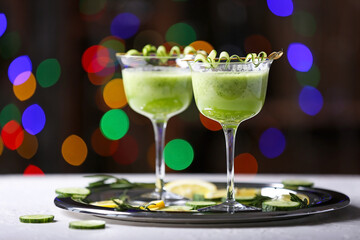 Glasses of tasty cucumber martini on table in bar