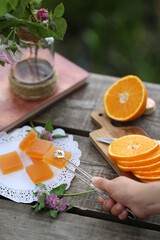 Sliced ​​orange, orange marmalade, book and a vase of flowers.
