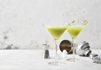 Glasses of tasty cucumber martini on white background