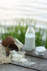 A bottle of coconut milk with a straw, white marmalade.
