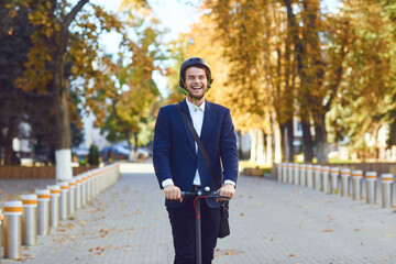 Young man in a helmet rides an electric scooter on a city street in summer © Studio Romantic