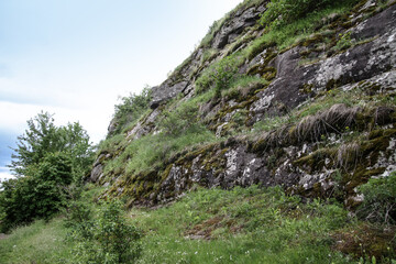 Fototapeta premium Nice mountain road with a beautiful view. A rock on the side of a dirt path. Stock landscape for design