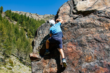 Kletternder Junge auf großem Felsen
