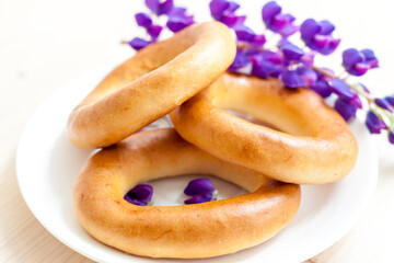 Sweet bagels and tender lupine flowers. Light composition with bright and purple flowers. A tender and romantic morning.