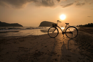 Fototapeta premium silhouette of bicycle at beach, bicycles on beach sunset or sunrise
