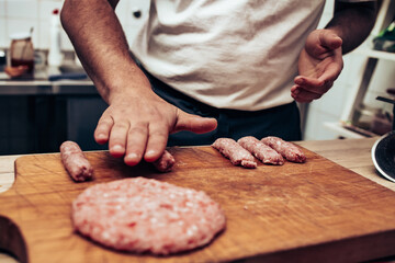 Restaurant chef preparing cevap and burger from minced beef meat.