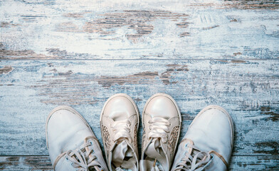 Father and daughter white shoes on shabby chic wooden background. Fathers day concept.