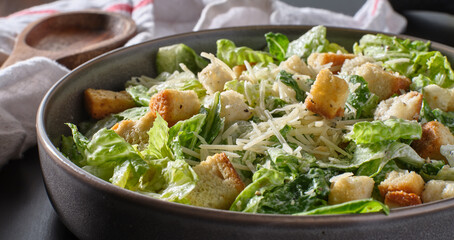 fresh caesar salad with croutons and parmasan cheese in bowl