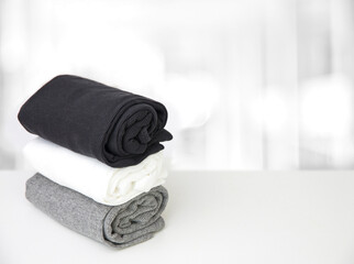 A stack of twisted T-shirts on a white table