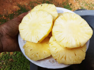 Slices of Pineapple on the serving plate. Delicious pineapple fruit plate.