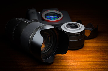Digital camera body with photo lens on wooden table, 3D rendering