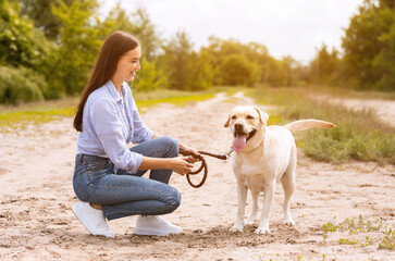 Smiling woman and her golden retriever walking outdoors