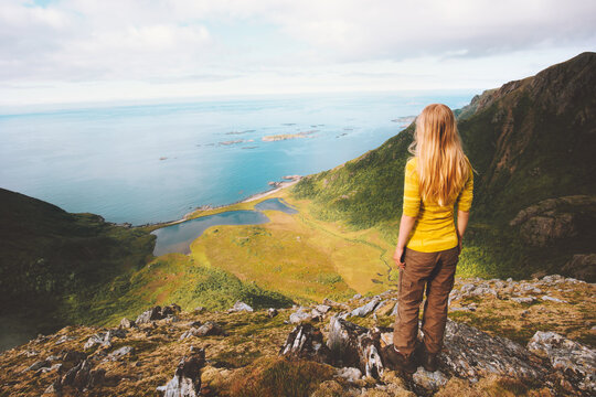 Woman tourist hiking alone on mountain summit cliff enjoying aerial ocean view summer travel vacations active healthy lifestyle adventure trip outdoor in Norway