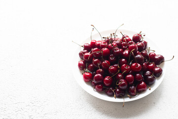 Cherry berry on a white plate . Summer berry. Berries on a plate on a white background. Article about berries.