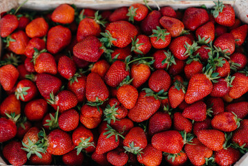 Ripe fresh strawberries close-up in a container for sale. Healthy diet