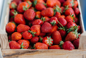 Ripe fresh strawberries close-up in a container for sale. Healthy diet