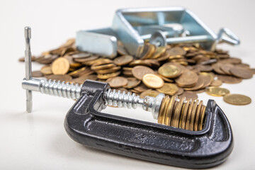 Coins squeezed in a carpenter's clamp. The image of the European currency in crisis.