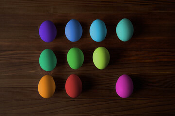 Colorful eggs for Easter on a wooden table. View from above.