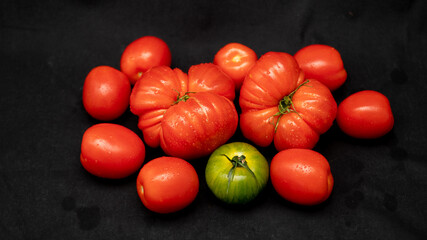 
Different varieties of tomatoes, on black background