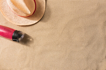 Fototapeta na wymiar Summer vacation composition. Water bottle and straw hat on sand