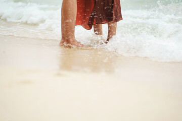 Legs of a young girl and guy on the ocean coast