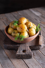 Young roasted potatoes with dill in a ceramic bowl