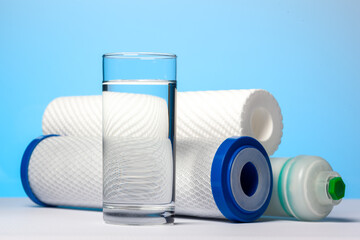 A glass of drinking water and filter cartridges