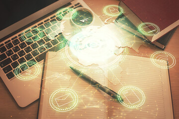 Social network hologram drawings over computer on the desktop background. Top view. Double exposure.