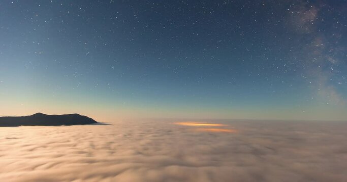 Lockdown time lapse shot of Milky Way over cloudscape by mountains against sky at night - Tofino, Canada