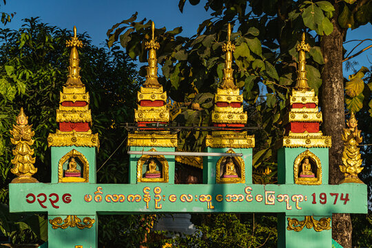 Decorative gate with little gilded stupas and Buddhist motifs in in Taungoo, Myanmar.