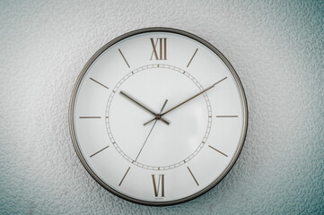 Gold clock on the wall on a homogeneous background