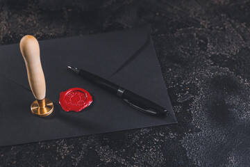 Envelope with notary public wax seal and pen on dark background - obrazy, fototapety, plakaty