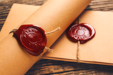 Scroll and envelope with notary public wax seal on table, closeup