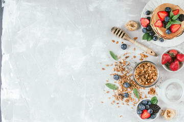 Naklejka na ściany i meble Healthy breakfast with american pancake, granola, fruits, berries on white background.